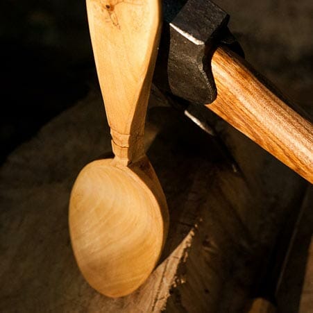 spoon a wooden spoon resting against an axe
